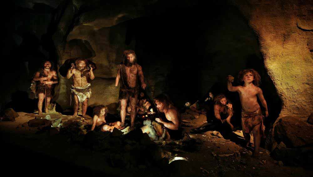A group of Neandertals in a rockshelter with firelight