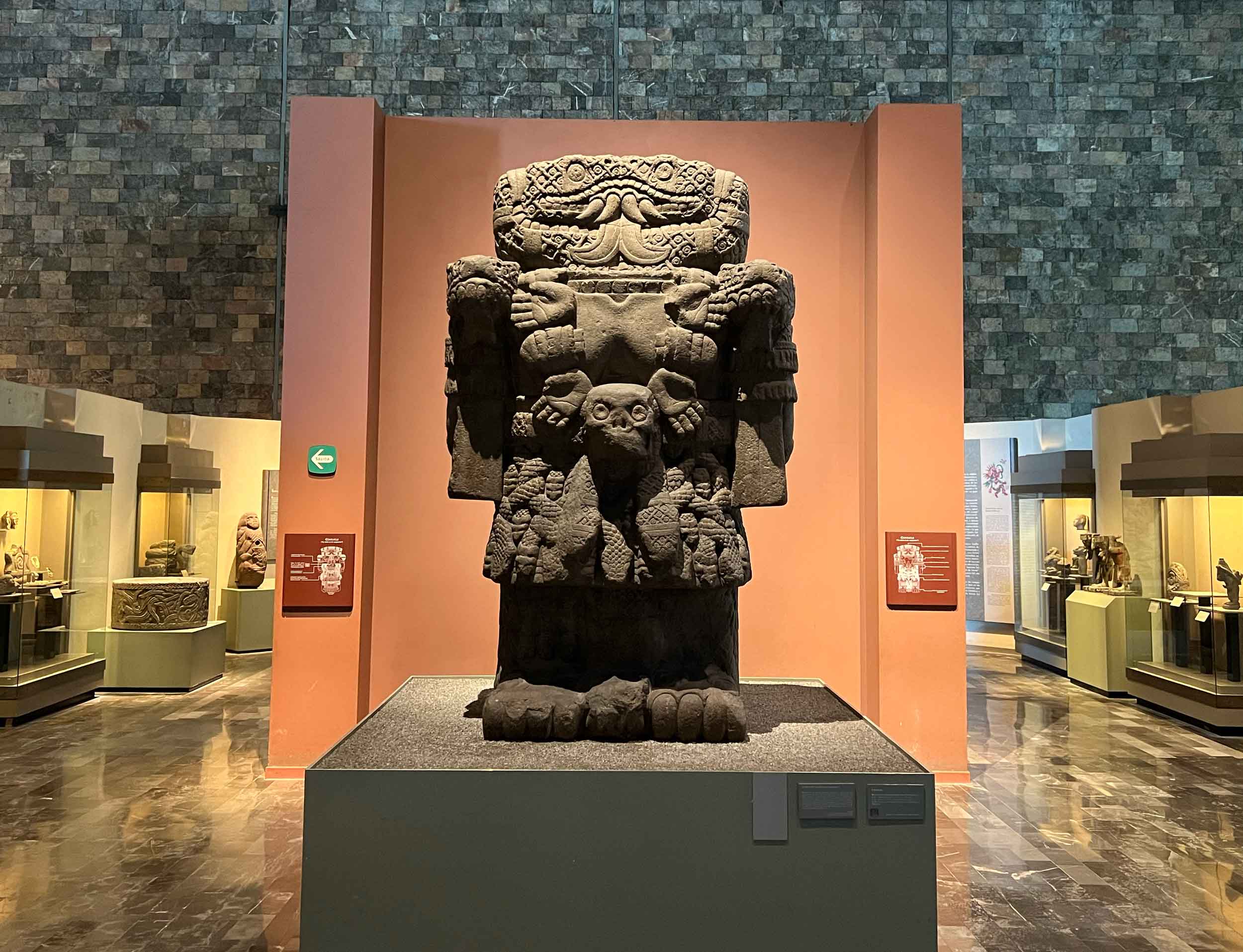 Large basalt figure of the goddess Cōātlīcue, represented with snake heads, snake skirt, hands and skulls adorning her body